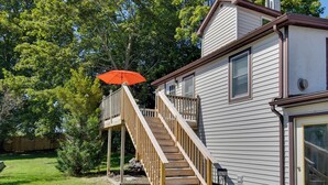 A two-story house with a wooden deck and a red umbrella. - Riverfront Couple's Retreat, 3 Mi to Seneca Lake! (Waterloo)