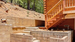 A wooden staircase leading to a deck with a view of a forested hillside. - Community Lake Access: Peaceful Cabin in Sonora! (Sonora)