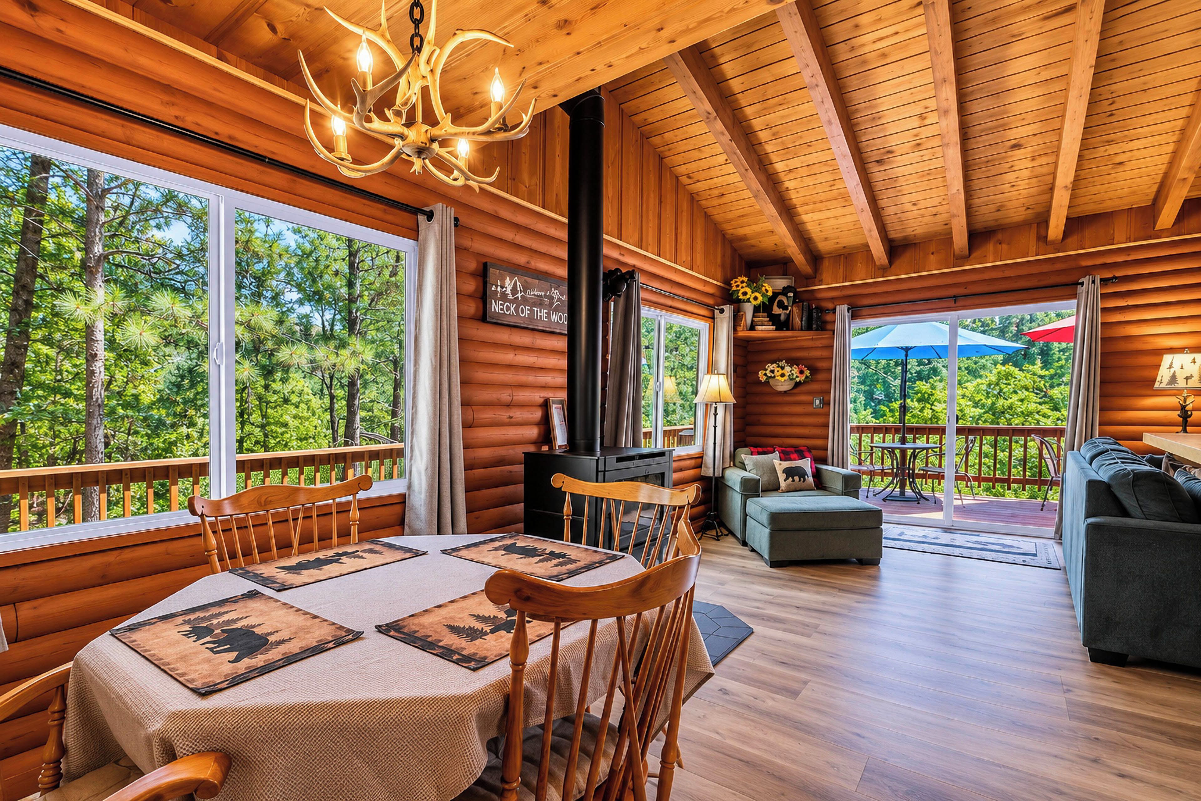A log cabin interior with a dining area, a sofa, and a fireplace.