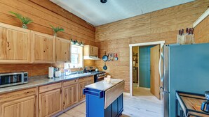 A kitchen with wooden cabinets, a microwave, a stove, and a refrigerator. - Ohio Cabin on 23 Acres: Fish, Hunt & Explore! (Lower Salem)