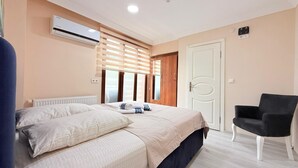 Ein Schlafzimmer mit Bett, Stuhl, Kleiderschrank und Klimaanlage.