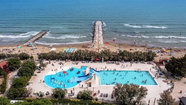 A beach resort with a large swimming pool, beach area, and ocean view. - Adria Holiday - Villaggio San Francesco (Caorle)