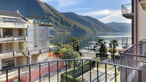Un edificio residencial con balcones que dan a un lago y montañas.
