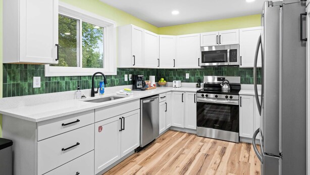 A modern kitchen with white cabinets, a stainless steel refrigerator, a microwave, an oven, and a dishwasher. - Movie Theater, Game room, 4BR near Spooky Nook (Hamilton)