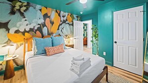 A bedroom with a bed, pillows, a ceiling fan, and a wall mural. - Movie Theater, Game room, 4BR near Spooky Nook (Hamilton)