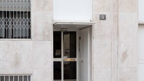 A building entrance with a metal gate, a door with a handle, and a number '5' sign. - Studio apartment a stone's throw from CityLife (Milano)