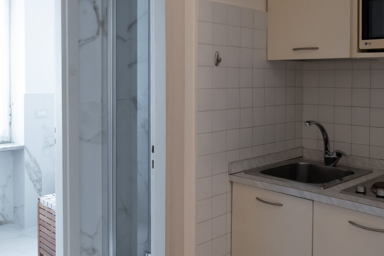 A modern kitchen with white cabinets, a sink, and a window.