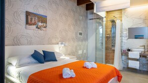 A hotel room with a bed, a shower, and a bathroom with a marble wall. - Room 106 at 'Le Saline Rooms Marzamemi' with Wi-Fi and Air Conditioning (Marzamemi)