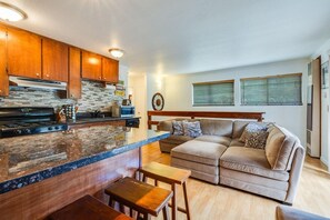 A modern kitchen with a granite countertop, wooden cabinets, and a built-in stove.