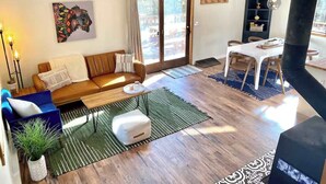 Un salon moderne comprenant un canapé, une table basse et un coin repas avec des chaises et une table.