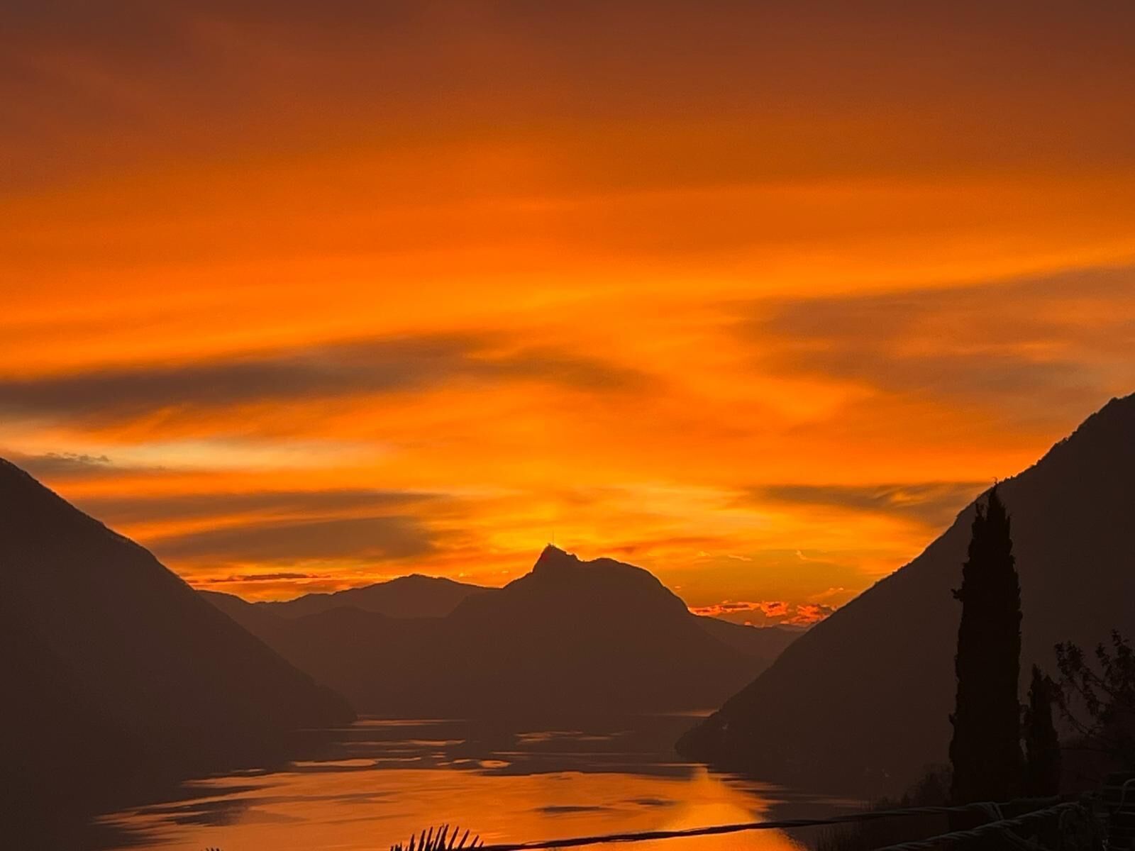 A mountainous landscape with a lake at sunset.