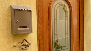 A wooden door with a glass panel and a mailbox on the wall.