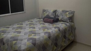 A bedroom with a bed, a window, and an air conditioning unit. - Complete apartment no turu 5 kms praias aracagy (São José de Ribamar)