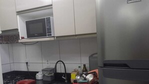 A kitchen with a stainless steel refrigerator, a microwave, a sink, and a stove. - Complete apartment no turu 5 kms praias aracagy (São José de Ribamar)