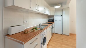 Cocina moderna con tostadora, lavaplatos, microondas y lavadora integrada.