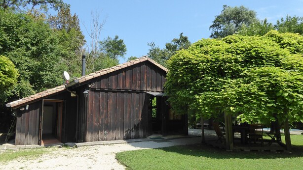 A rustic wooden building with a sloped roof, a door, and a small porch area. - Chalet Fagarè Pool Sauna Prosecco Hills (Cornuda)