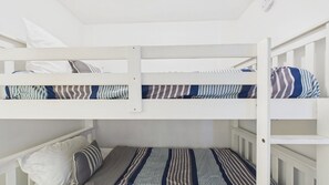 Ein Stockbett mit gestreifter Bettwäsche und Kissen.