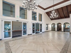 Eine geräumige Lobby mit Fischgrätparkett, großen Glastüren und einem Chandelier.