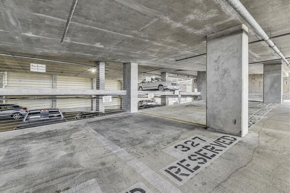 A multi-level parking garage with concrete pillars and marked parking spaces.