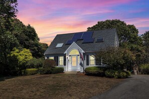 A house with solar panels, a front door, and a driveway.