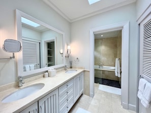 A modern bathroom with two sinks, a large mirror, and a walk-in shower. - Villatre 2 Bedroom Villa (Mullins)