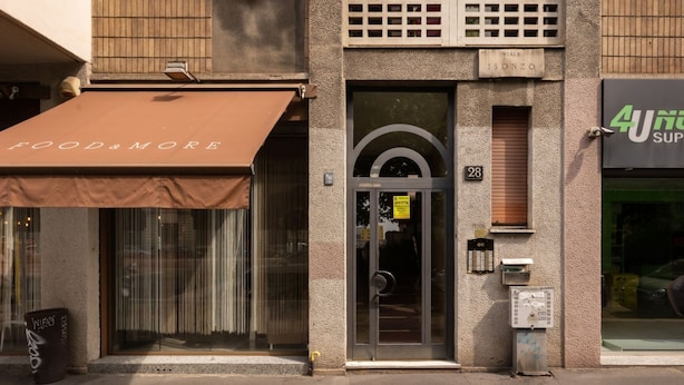A building with a brown awning labeled "FOOD & MORE" and a storefront with a sign "4UN".