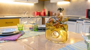A kitchen with a table set for dining, featuring a glass vase with decorative elements. - Apartment 'Il Borgo Ulivo' with Lake View, Wi-Fi and Air Conditioning (Castelletto)