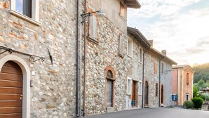 A stone building with arched windows and a flat roof. - Apartment 'Il Borgo Ulivo' with Lake View, Wi-Fi and Air Conditioning (Castelletto)