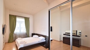 A modern bedroom with a bed, a mirror, and a dresser.