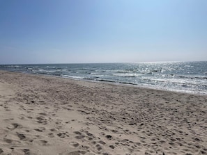 A beach with footprints leading to the water, a clear sky, and the ocean. - 5 Star Holiday Home in Ystad (Ystad)