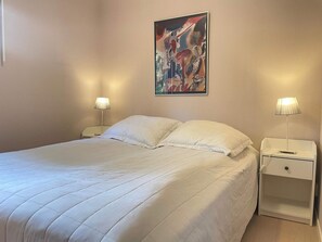 A hotel room with a queen-sized bed, two bedside tables, and a painting on the wall. - 5 Star Holiday Home in Ystad (Ystad)