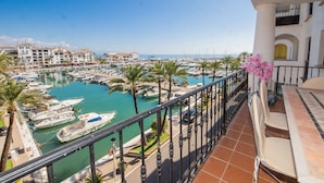 Ein Yachthafen mit Booten, Palmen und Blick auf das Meer.