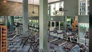 Un gimnasio moderno con diversas máquinas de cardio, equipo de levantamiento de pesas y piso a cuadros.