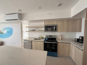 Une cuisine moderne équipée d’un four à micro-ondes, d’une cuisinière et d’un évier.