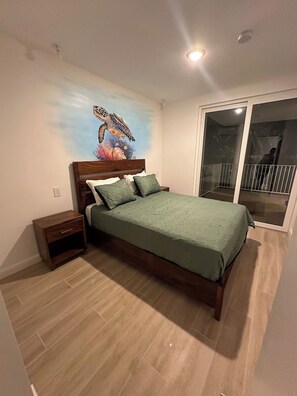 Ein Schlafzimmer mit Bett, Nachttisch und Wandgemälde.