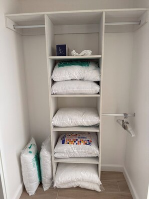 A storage closet with shelves containing bags and a hanging rack. - Luxury Ocean Front Condo (Jaco Beach)