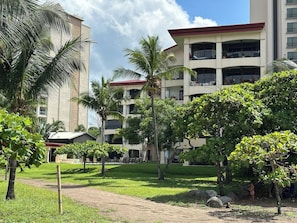 Ein Hotel mit mehreren Stockwerken, Außenbereich und Palmen.