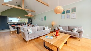 A modern living room with a sofa set, a coffee table, and a dining area with a table and chairs. - Welcome to Marius and Augustin's Home (Goulven)