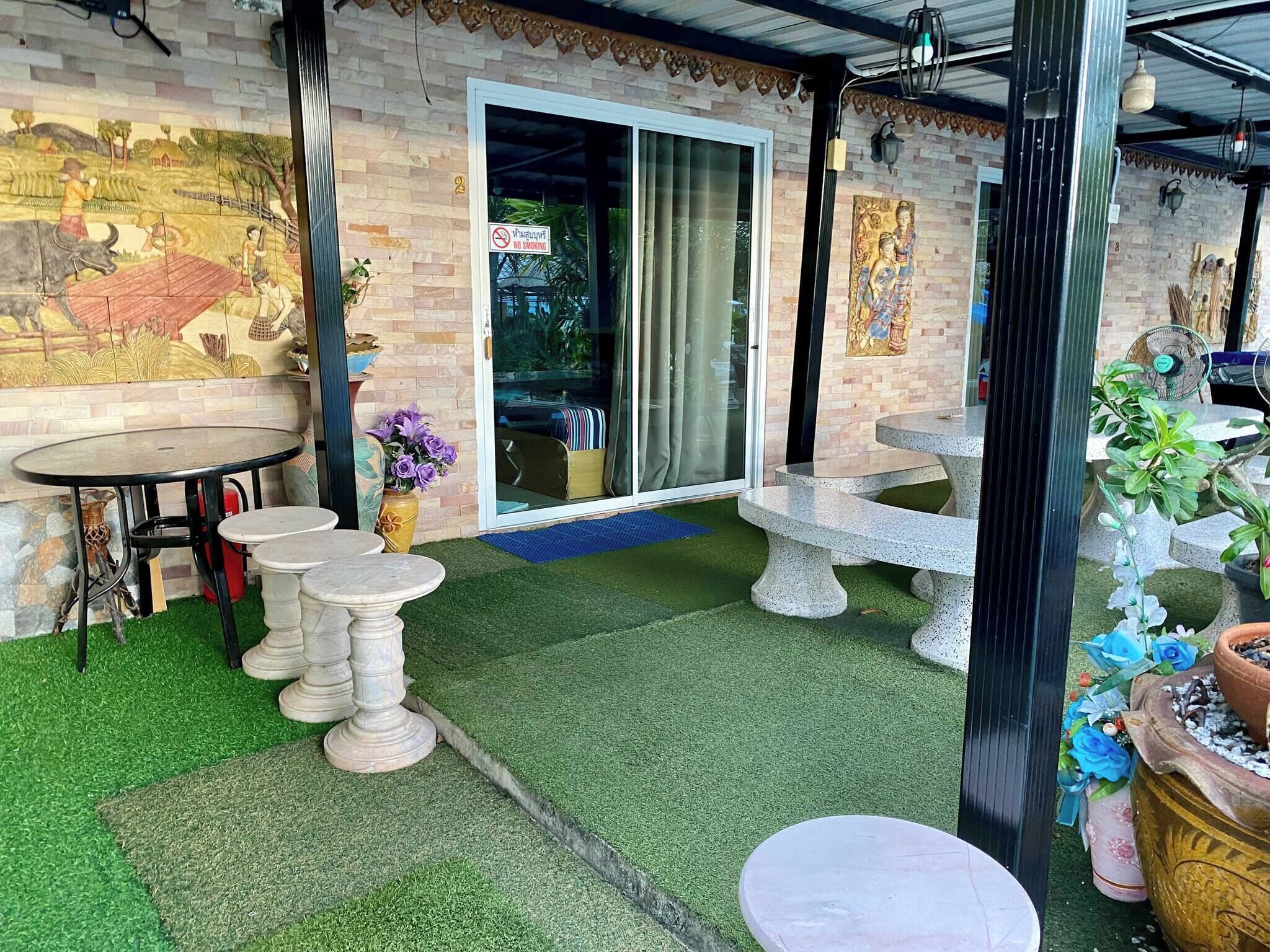 A patio area with a mural, outdoor seating, and a 'No Smoking' sign.