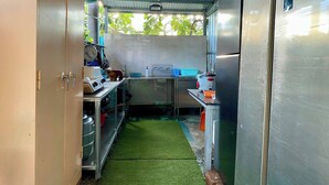A compact kitchen with a metal roof, a small sink, and a refrigerator. - Villa Na Wande Sattahip (Sattahip)