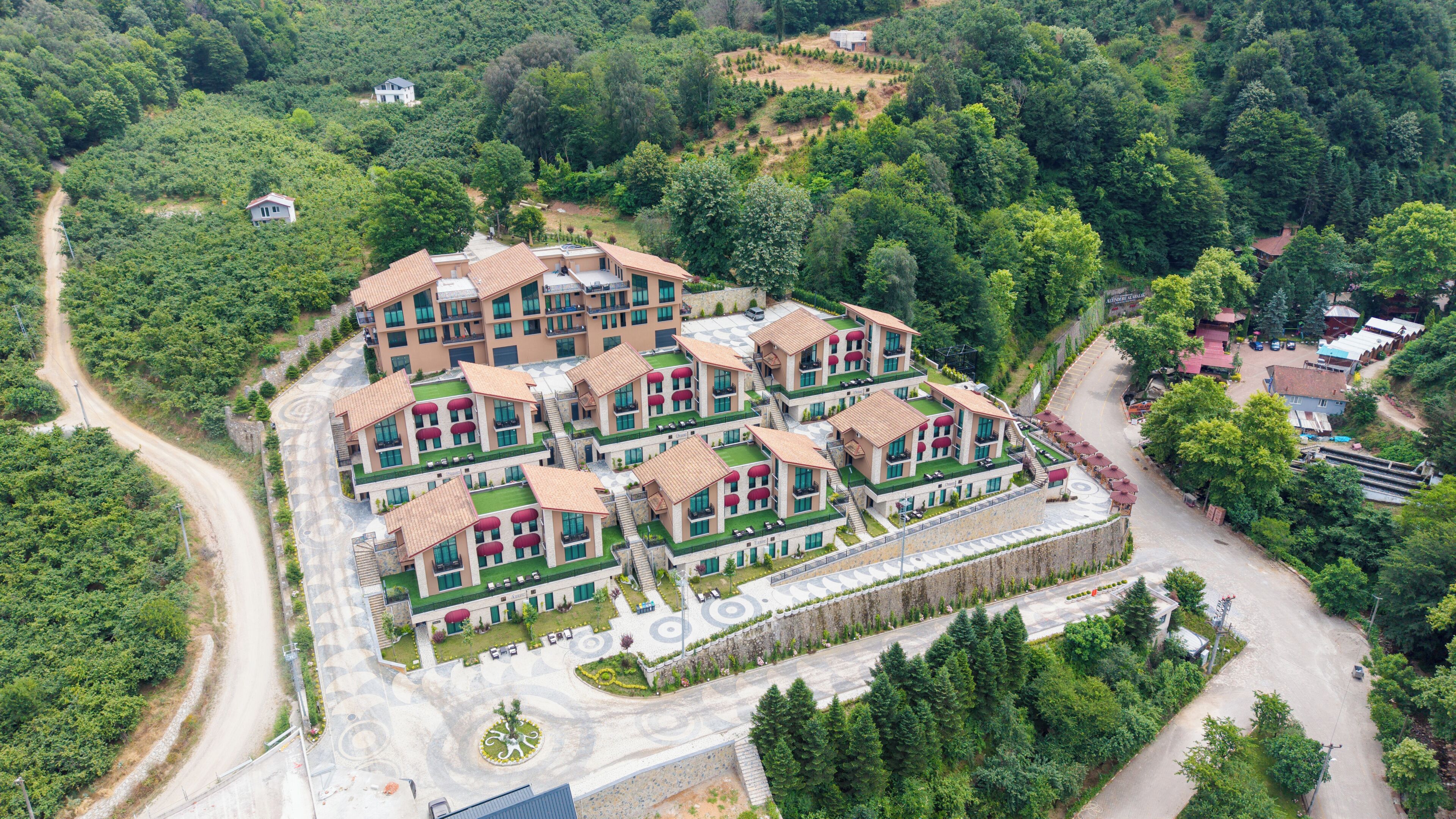 Um hotel de vários andares com um pátio central, rodeado por vegetação exuberante.