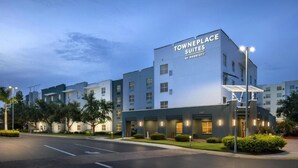 A modern hotel named Towneplace Suites by Marriott with a contemporary design, featuring multiple floors and a well-lit entrance. - Fully Equipped Kitchen in Modern Suite with Airport Shuttle and Swimming Pool (Tampa)