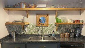 Una cocina moderna con un lavabo doble, electrodomésticos de acero inoxidable y una cafetera.