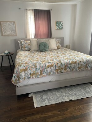 A neatly made bed with a patterned bedspread, a bedside table with a tissue box, and a decorative pillow. - Fabulous 2 bedroom Bungalow in Charming Rose District, Downtown Broken Arrow (Broken Arrow)