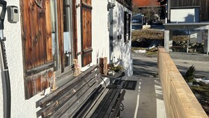 A building with wooden shutters, a bench outside, and a metal sign. - Beim Patzelt - Holiday home Nesselwang | Königscard | Pets welcome (Nesselwang)