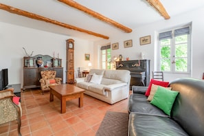 A living room with a sofa, armchair, wooden coffee table, and a fireplace.