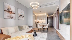 A modern living room with a sofa, coffee table, and artwork on the wall. - GLOBALSTAY. The Crest Tower C Apartments (Dubai)
