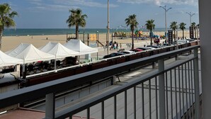 A beach view with tents, palm trees, and a hotel sign. - Holiday Home 'Face À La Mer 2' with Private Terrace and Air Conditioning (Port la nouvelle)