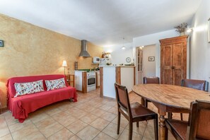 Une cuisine compacte comprenant un coin repas, un canapé et un meuble en bois.