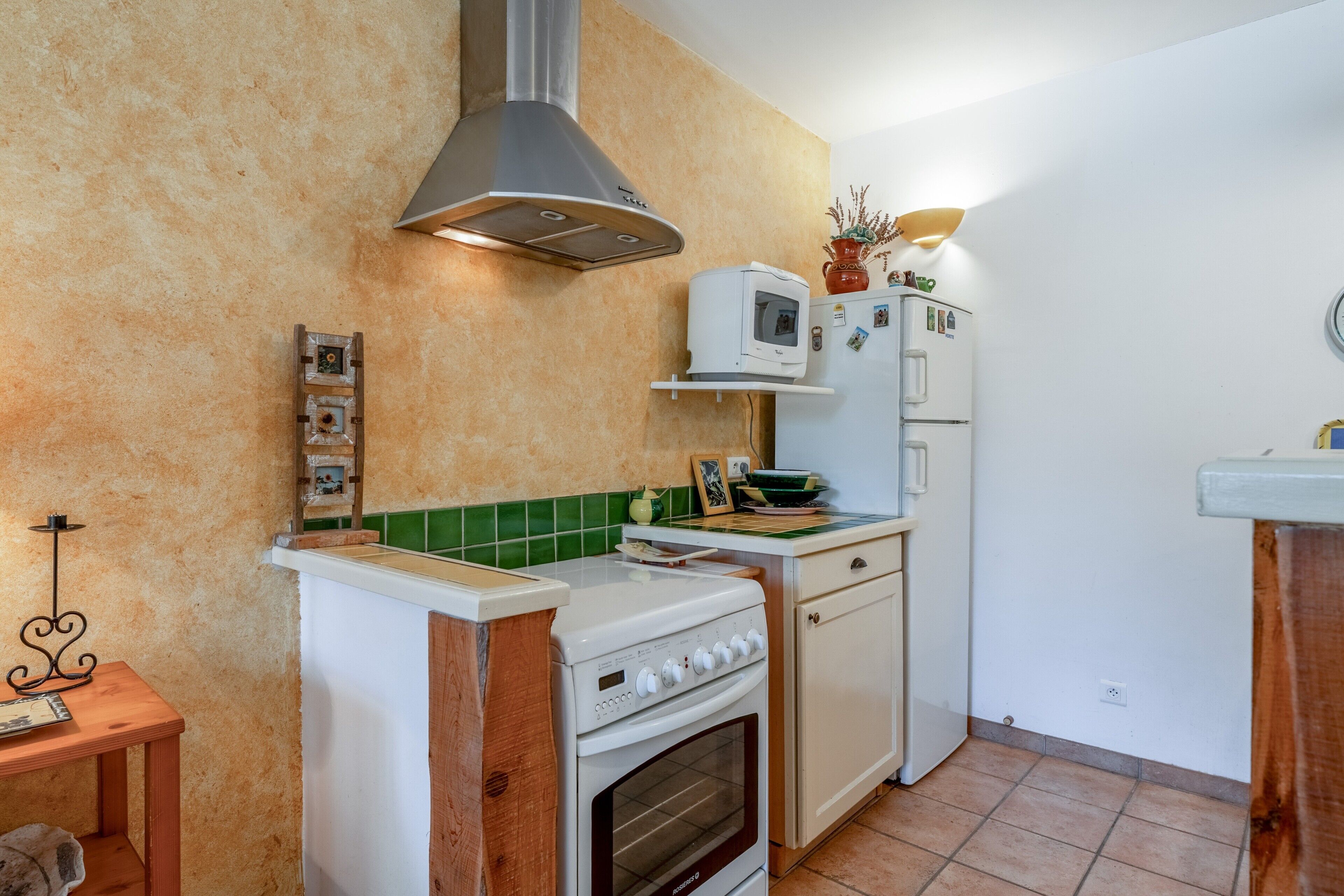 A compact kitchen with a stove, oven, microwave, and refrigerator.